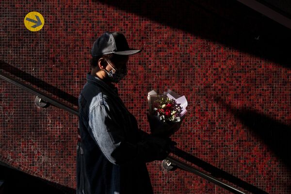 一名香港青年手持情人節玫瑰。 - 俄羅斯衛星通訊社