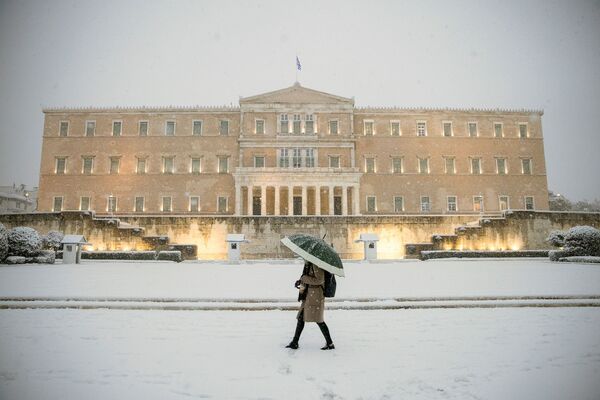 希臘雅典，一名女子打著傘從議會大樓前走過。 - 俄羅斯衛星通訊社