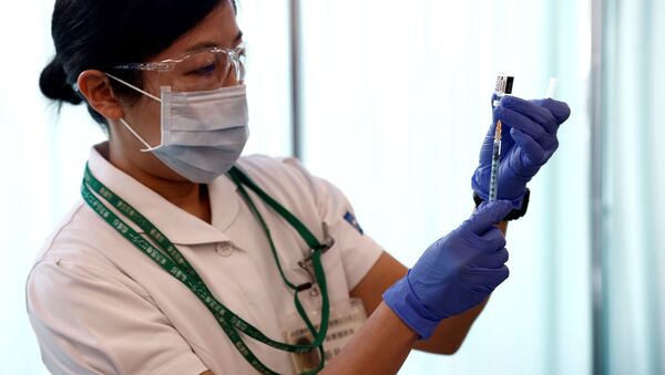 Медработник с шприцом и вакциной Pfizer во время старта вакцинации в Токио  - 俄羅斯衛星通訊社