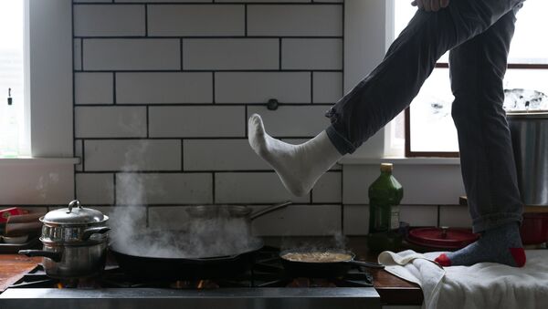 Мужчина греет ноги над газовой плитой в Остине, штат Техас, США - 俄羅斯衛星通訊社