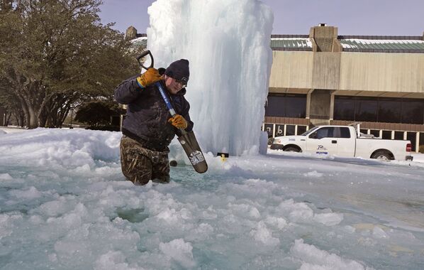 得州理查森，一名工人在冰凍的噴泉里把冰打碎。 - 俄羅斯衛星通訊社