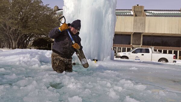 Рабочий ломает лед в замерзшем фонтане в Ричардсоне, штат Техас, США - 俄羅斯衛星通訊社