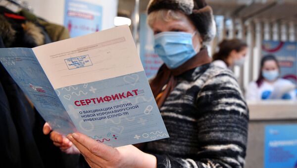 Женщина держит в руках сертификат о вакцинации от СOVID-19 - 俄羅斯衛星通訊社