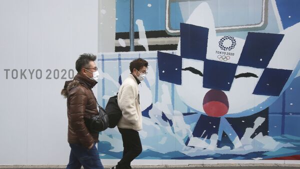 Люди проходят мимо плакатов, рекламирующих Олимпийские игры в Токио - 俄罗斯卫星通讯社