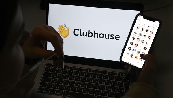 Приложение Clubhouse на экране смартфона на фоне экрана ноутбука - 俄羅斯衛星通訊社