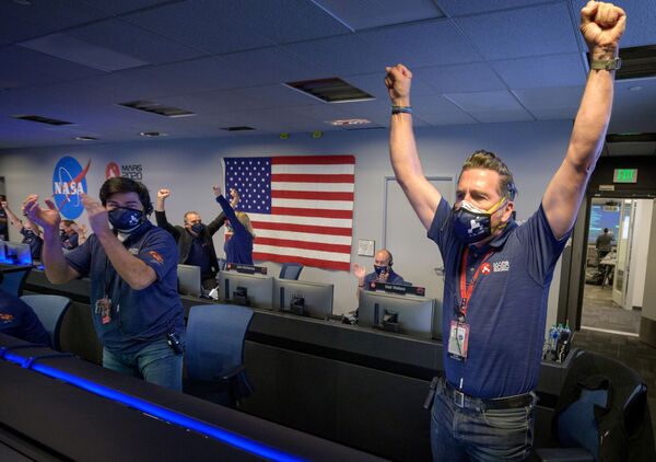 美國宇航局工作人員收到“毅力號”火星探測器成功登陸的確認信息後，紛紛起立舉手歡呼。 - 俄羅斯衛星通訊社