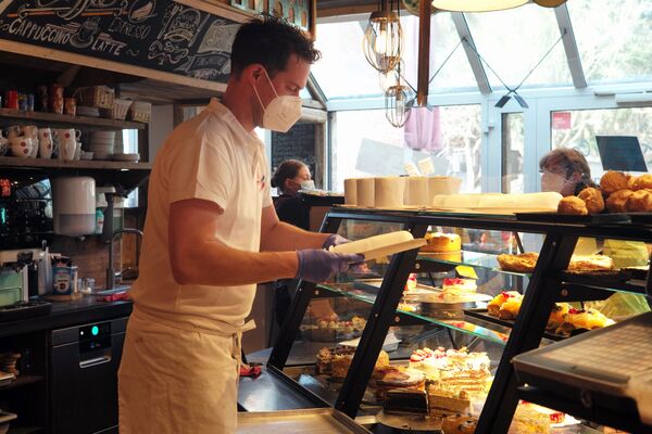 多特蒙德Schuerener Backparadies咖啡店员工正在往货架上摆放新鲜的甜点。 - 俄罗斯卫星通讯社