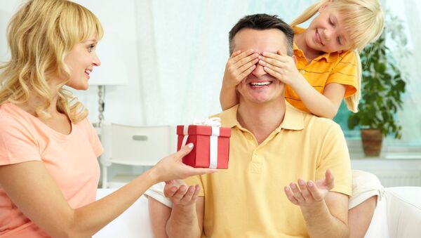 Женщина и ребенок дарят подарок мужчине - 俄罗斯卫星通讯社