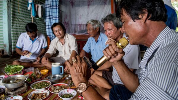 Мужчина поет в микрофон во время ужина с друзьями, Вьетнам  - 俄罗斯卫星通讯社