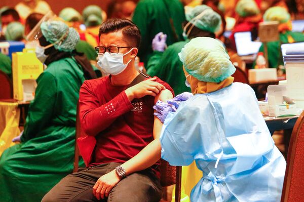 印度尼西亚一男子接种新冠疫苗。
 - 俄罗斯卫星通讯社