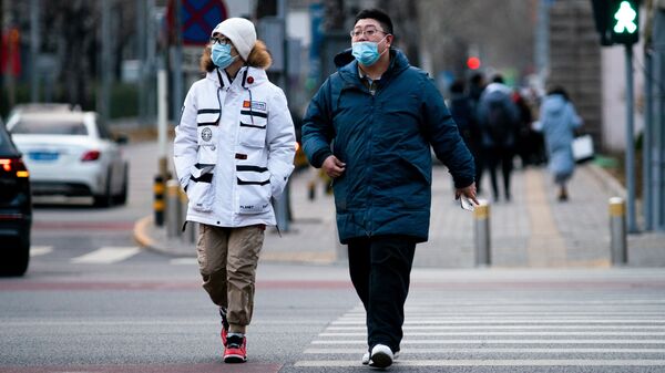  Прохожие на одной из улиц через год после начала пандемии в Пекине.  - 俄罗斯卫星通讯社