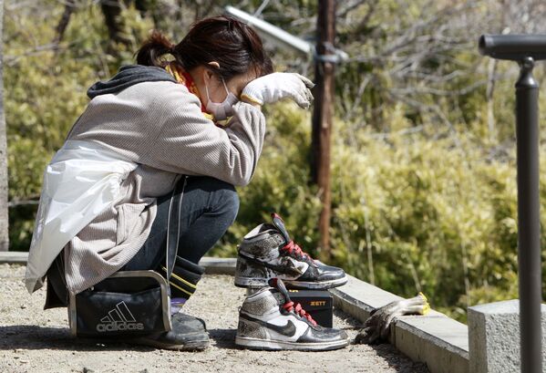 日本，一個女孩打掃完廢墟後正在休息。 - 俄羅斯衛星通訊社