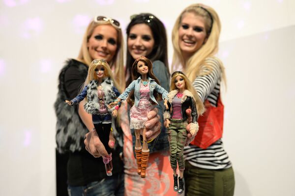 在纽伦堡国际玩具展的美泰公司的展台上，模特与穿着相似服装的芭比娃娃合影。 - 俄罗斯卫星通讯社