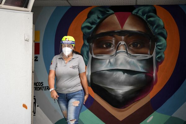 委内瑞拉加拉加斯，医护人员戴着口罩从涂鸦墙前走过。 - 俄罗斯卫星通讯社