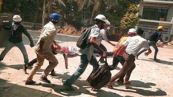 Люди несут на носилках человека, пострадавшего во время акции протеста в Янгоне, Мьянма - 俄罗斯卫星通讯社