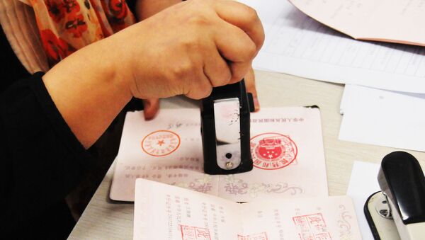 Сотрудник китайского Центра регистрации брака ставит штамп в свидетельство о разводе пары - 俄羅斯衛星通訊社
