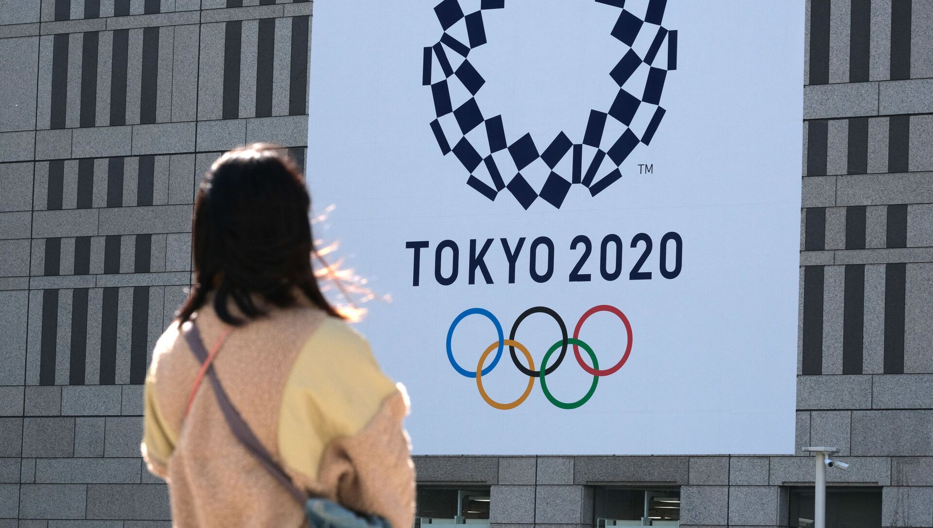 Девушка смотрит на баннер с логотипом Олимпиады в Токио - 俄罗斯卫星通讯社, 1920, 31.07.2021