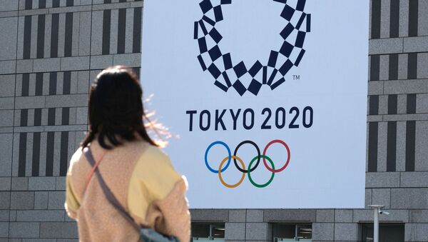 Девушка смотрит на баннер с логотипом Олимпиады в Токио - 俄羅斯衛星通訊社