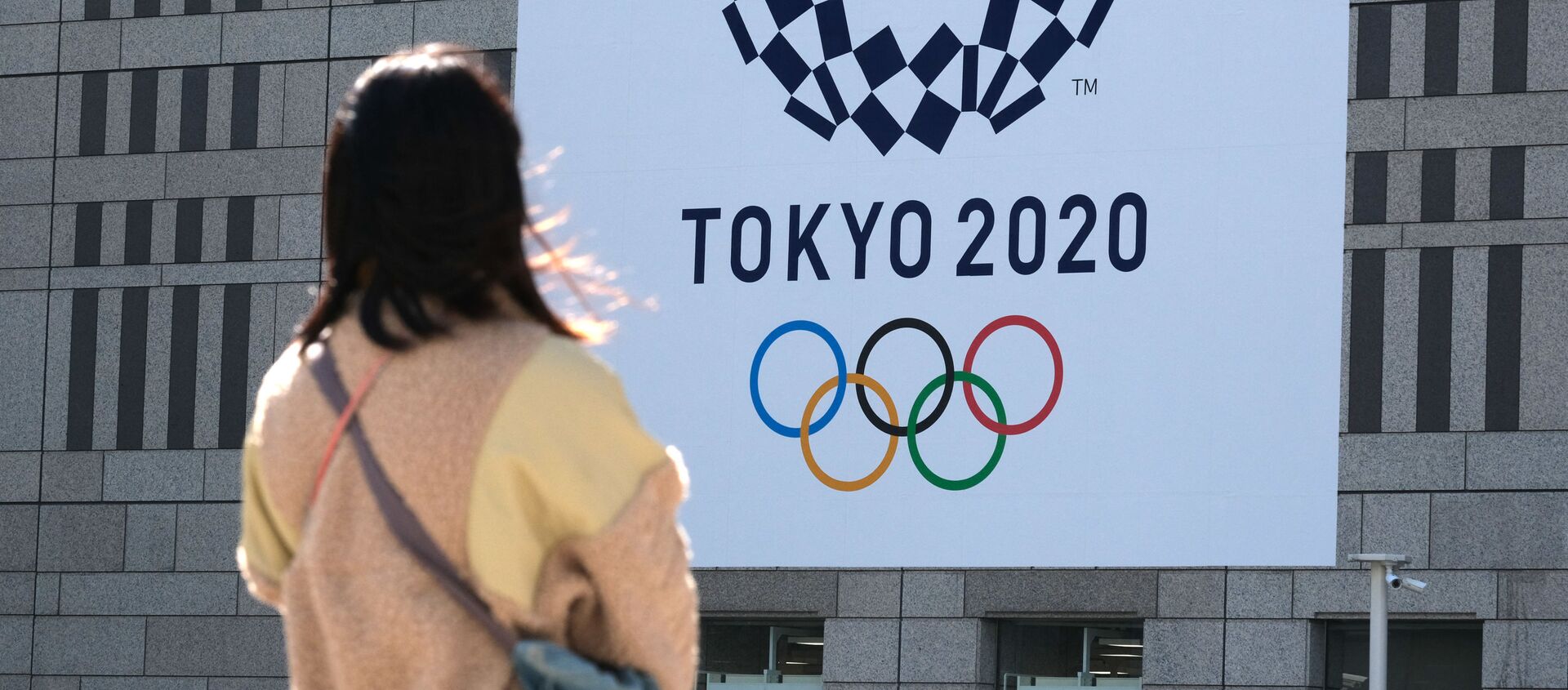 Девушка смотрит на баннер с логотипом Олимпиады в Токио - 俄羅斯衛星通訊社, 1920, 29.03.2021