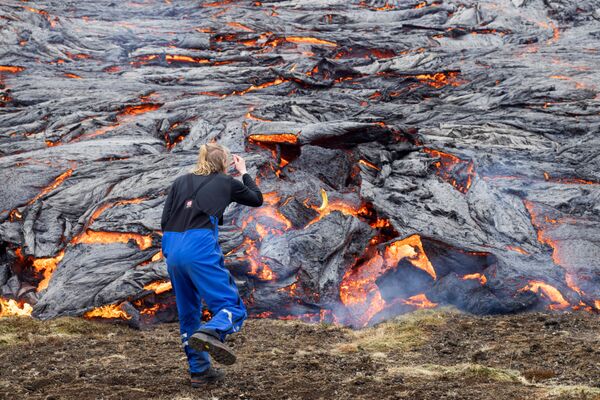 冰島火山爆發後，一名男子觀看熔岩。 - 俄羅斯衛星通訊社