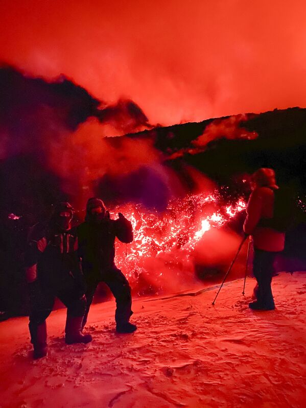 俄罗斯勘察加半岛克柳切夫火山爆发期间，游客摆姿势拍照。 - 俄罗斯卫星通讯社