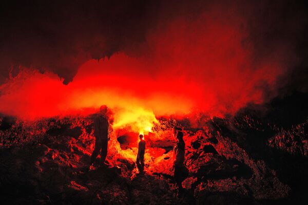 俄羅斯堪察加邊疆區托爾巴奇克火山噴發大裂縫地區“茲韋茲達”錐形熔岩洞穴中的遊客。 - 俄羅斯衛星通訊社