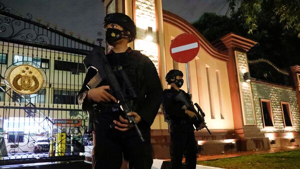 Вооруженные полицейские охраняют ворота штаб-квартиры национальной полиции после предполагаемого нападения боевиков в Джакарте, Индонезия. - 俄罗斯卫星通讯社