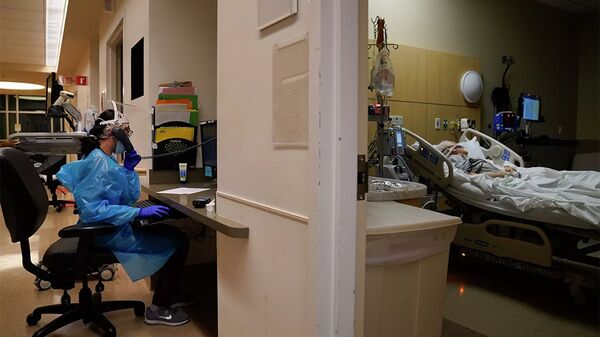 Пациент лежит на кровати в отделении COVID-19 в Медицинском центре Святого Креста Провиденса в районе Мишн-Хиллз в Лос-Анджелесе - 俄罗斯卫星通讯社