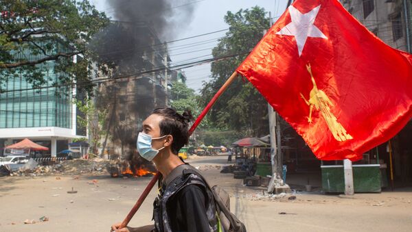 Мужчина держит флаг Национальной лиги за демократию во время акции протеста против военного переворота в Янгоне, Мьянма - 俄罗斯卫星通讯社