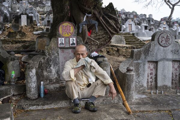 香港清明節期間，一名男子在公墓的祖墳現場。 - 俄羅斯衛星通訊社