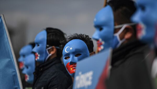 Demonstrators wearing a mask painted with the colours of the flag of East Turkestan - 俄罗斯卫星通讯社