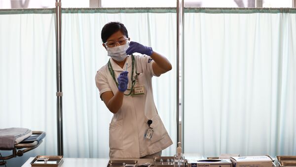 Медицинский работник наполняет шприц дозой вакцины Pfizer-BioNTech COVID-19 в Токийском медицинском центре  - 俄羅斯衛星通訊社