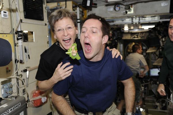 法国航天员托马·佩斯克与美国航天员威特森在国际空间站舱内就餐。 - 俄罗斯卫星通讯社