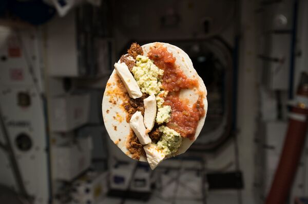 美国航天员提姆·科普拉在国际空间站内进餐。
 - 俄罗斯卫星通讯社