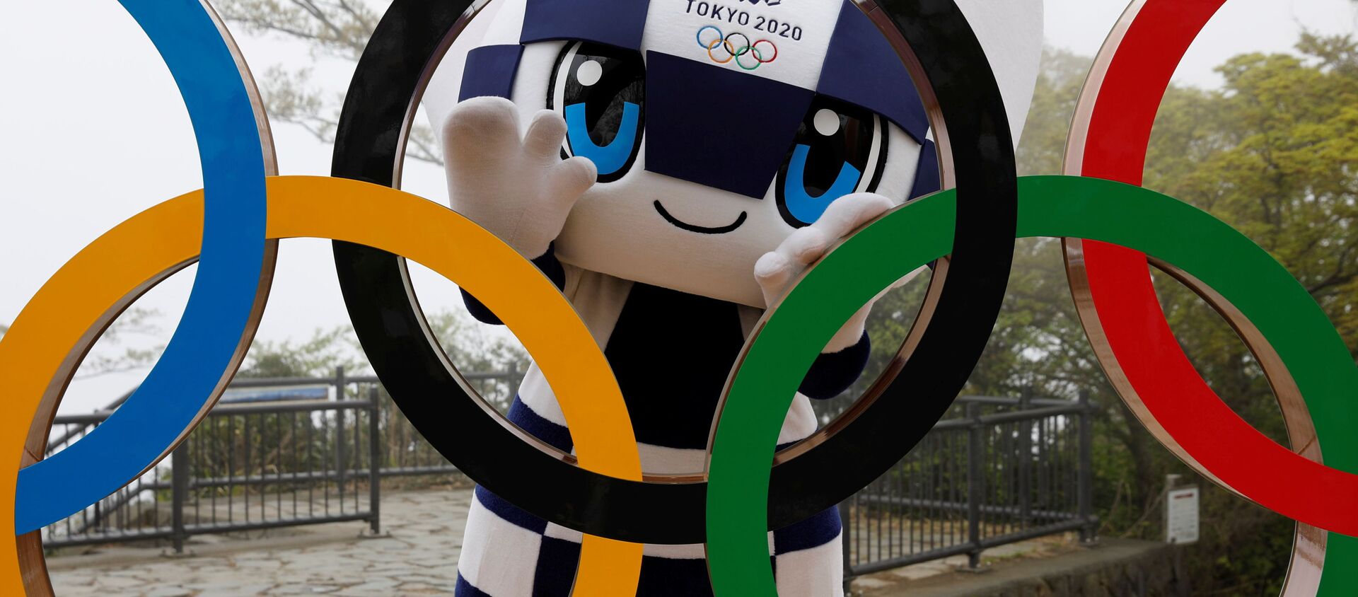 东京奥运会吉祥物miraitowa与奥运五环雕像