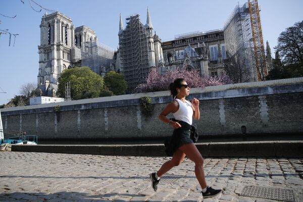 一个姑娘从巴黎圣母院前跑步经过。 - 俄罗斯卫星通讯社