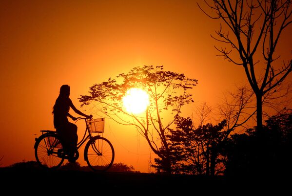 印度女孩在夕陽下騎行。 - 俄羅斯衛星通訊社