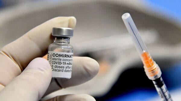 Медицинский работник держит шприц и флакон вакцины Comirnaty от Pfizer-BioNTech против Covid-19, Италия - 俄罗斯卫星通讯社