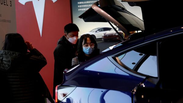 Посетители осматривают внедорожник Tesla Model Y в шоуруме в Пекине. - 俄罗斯卫星通讯社