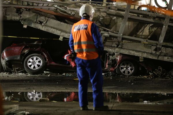 在Olivos和Tesonko站之间发生轨道交通桥梁坍塌时被卡在桥下的汽车，救援人员站在它的前面 - 俄罗斯卫星通讯社