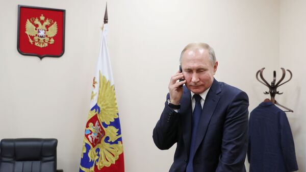 Президент России Владимир Путин во время разговора по телефону - 俄罗斯卫星通讯社