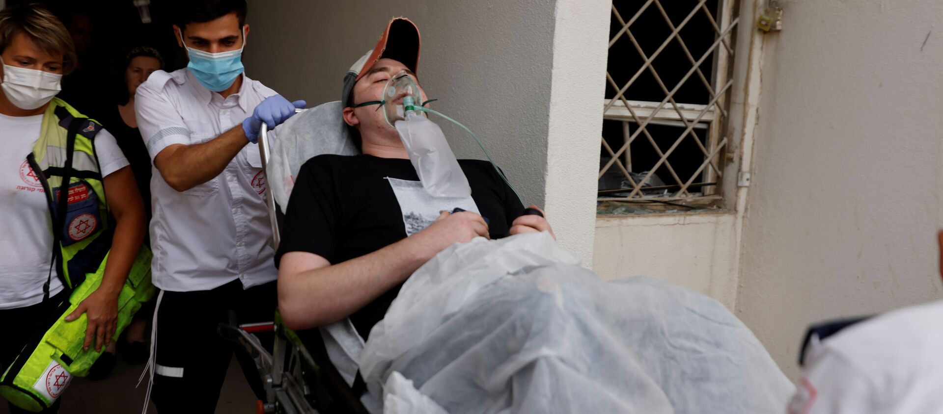 Израильские медики эвакуируют человека, получившего ранение в результате попадания ракеты из сектора Газа в жилой дом в Ашкелоне, на юге Израиля - 俄罗斯卫星通讯社, 1920, 12.05.2021