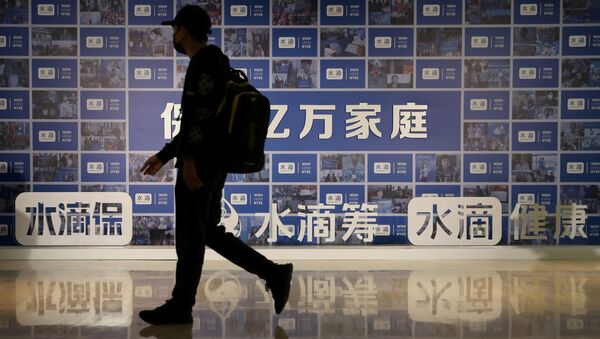 Мужчина проходит мимо рекламного щита с вывесками китайской страховой компании Waterdrop Inc, поддерживаемой Tencent, в преддверии первичного публичного размещения акций (IPO) в США на Нью-Йоркской фондовой бирже (NYSE). - 俄羅斯衛星通訊社