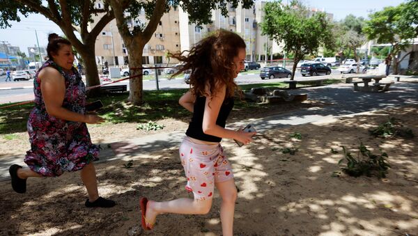 Люди бегут в Ашкелоне под звуки сирены, предупреждающие о приближающейся ракете, запущенной из сектора Газа  - 俄羅斯衛星通訊社