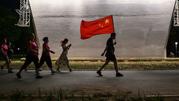 Мужчина с флагом Китая идет по парку в Ухани - 俄羅斯衛星通訊社
