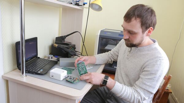 斯捷潘•延申，“医学工程”实验室工程师，他手中拿着的是科学家开发的用于测量心脏微电位的软硬件结合系统（无传感器） - 俄罗斯卫星通讯社