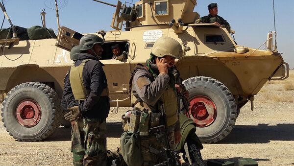 Афганские силы безопасности стоят возле бронетранспортера во время продолжающихся боев между афганскими силами безопасности и боевиками Талибана в районе Бушарана на окраине Лашкаргаха, столицы провинции Гильменд. - 俄羅斯衛星通訊社