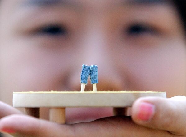 2005年,韩国首尔“李维斯”(Levi's Jeans)员工展示仅为1厘米长的世界最小牛仔裤。 2005年,韩国首尔“李维斯”(Levi's Jeans)员工展示仅为1厘米长的世界最小牛仔裤。 - 俄罗斯卫星通讯社