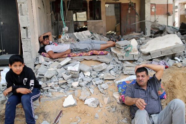 巴勒斯坦居民在損毀的房屋外休息。
 - 俄羅斯衛星通訊社