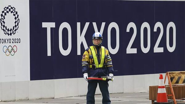 Охранник на фоне баннера олимпийских игр в Токио - 俄羅斯衛星通訊社